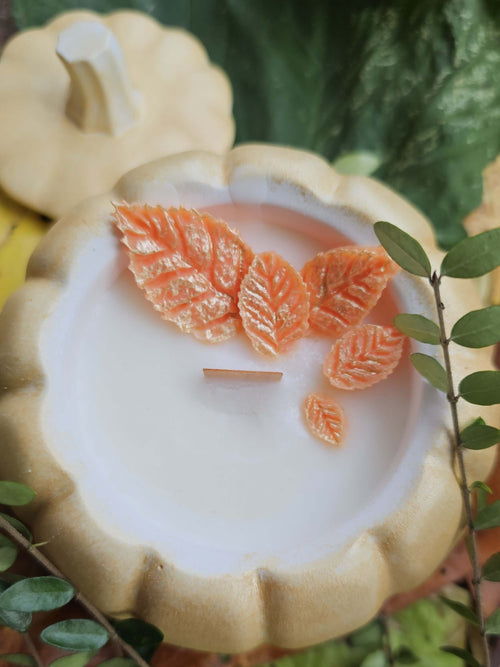 Pumpkin soy candle with wooden wick featuring orange leaf details, perfect for autumn décor.