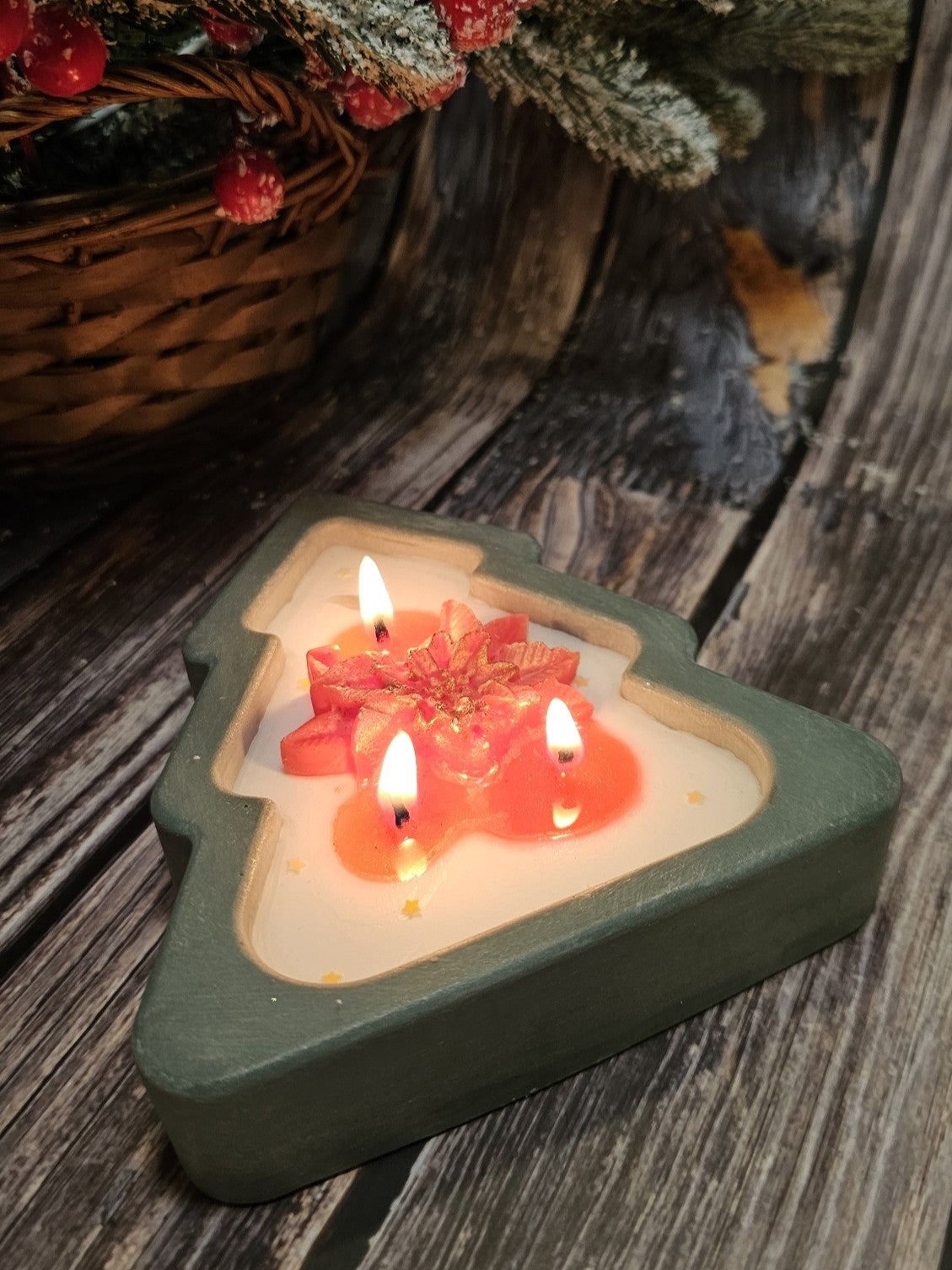 Christmas tree candle in green handmade gypsum form, decorated with star accents and poinsettia details.